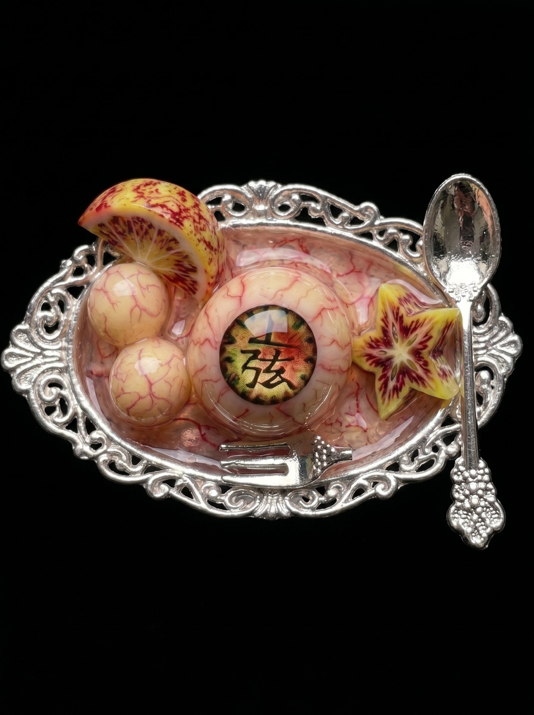 Collaborative feast object with eye jewelry and silver utensils